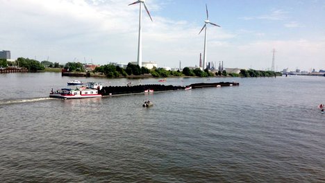 Ein Schubverband auf der Elbe bringt Steinkohle, im Hintergrund das KoKW Moorburg