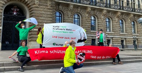 Menschen mit Bannern vor dem Hamburger Rathaus
