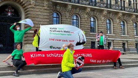 Menschen mit Bannern vor dem Hamburger Rathaus