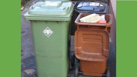 Drei verschiedene Mülltonnen, darunter eine Biotonne, die mit Verpackungsmaterial gefüllt wurde. Foto: Mussklprozz auf wikimedia CC-BY-SA 3.0
